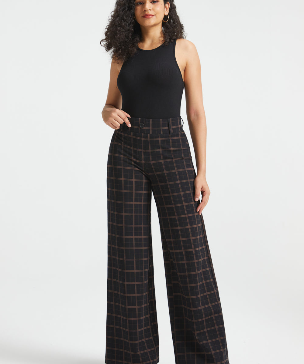 Woman wearing Black Brown Plaid high-waisted wide-leg Dress Pant Yoga Pants with a black sleeveless top and black heels, full front view