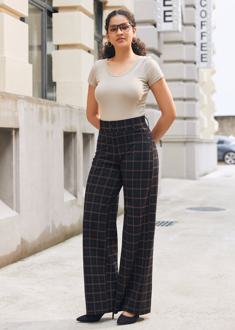 Woman wearing Black Brown Plaid high-waisted wide-leg pants with a neutral short-sleeve top outdoors