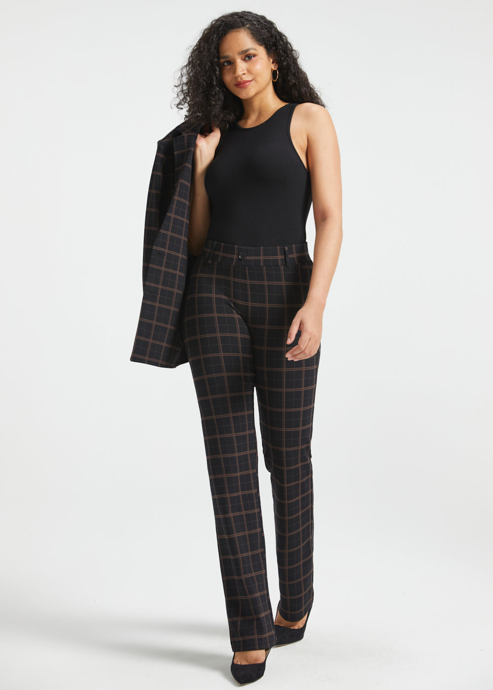 Full-length woman wearing Black Brown Plaid straight-leg Dress Pant Yoga Pants with a black sleeveless top and matching blazer over her shoulder