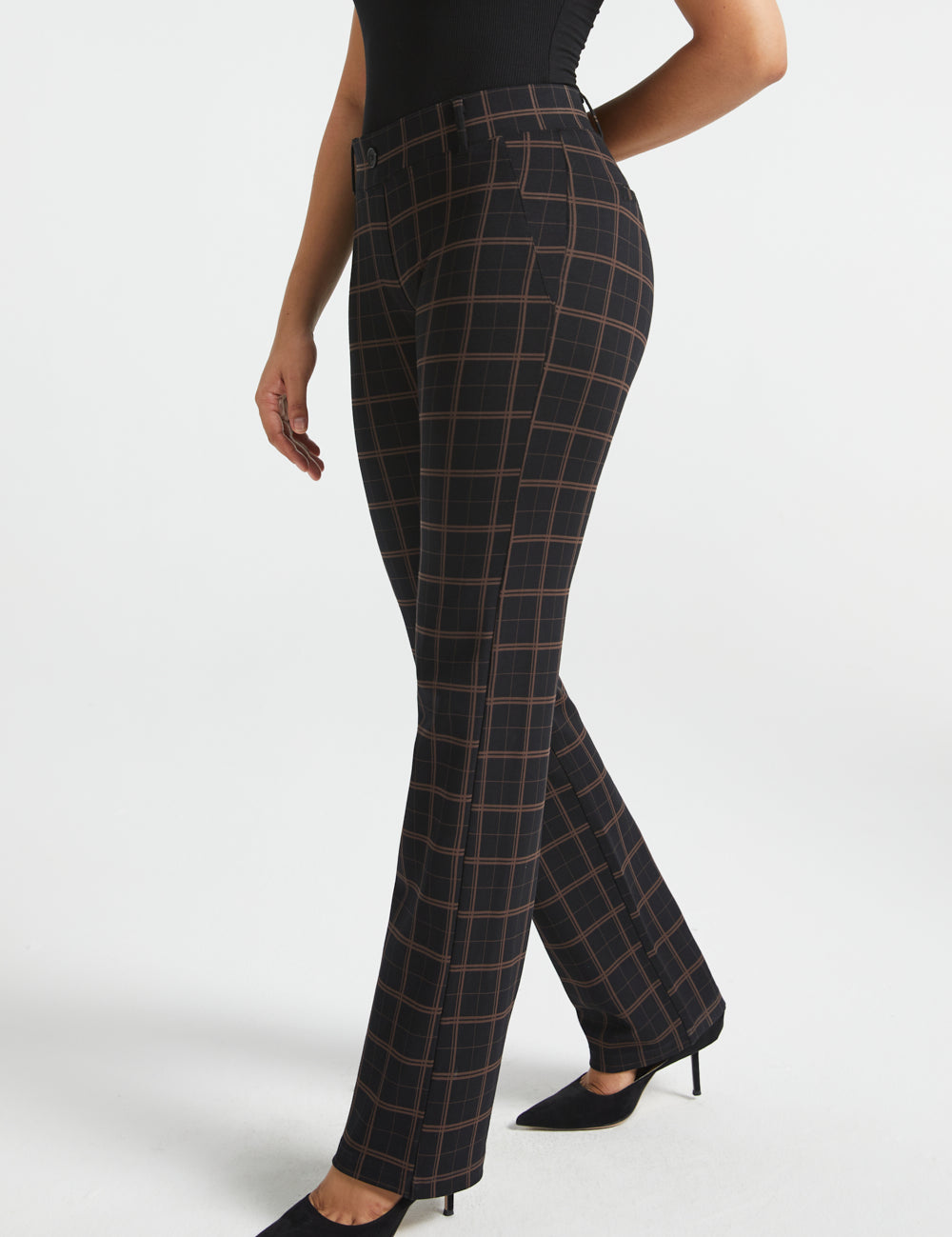 Woman wearing Black Brown Plaid straight-leg Dress Pant Yoga Pants with a black sleeveless top and black heels, side view