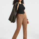 Woman wearing Camel Mini Houndstooth straight-leg Dress Pant Yoga Pants with a black top, brown heels and blazer draped over her shoulder