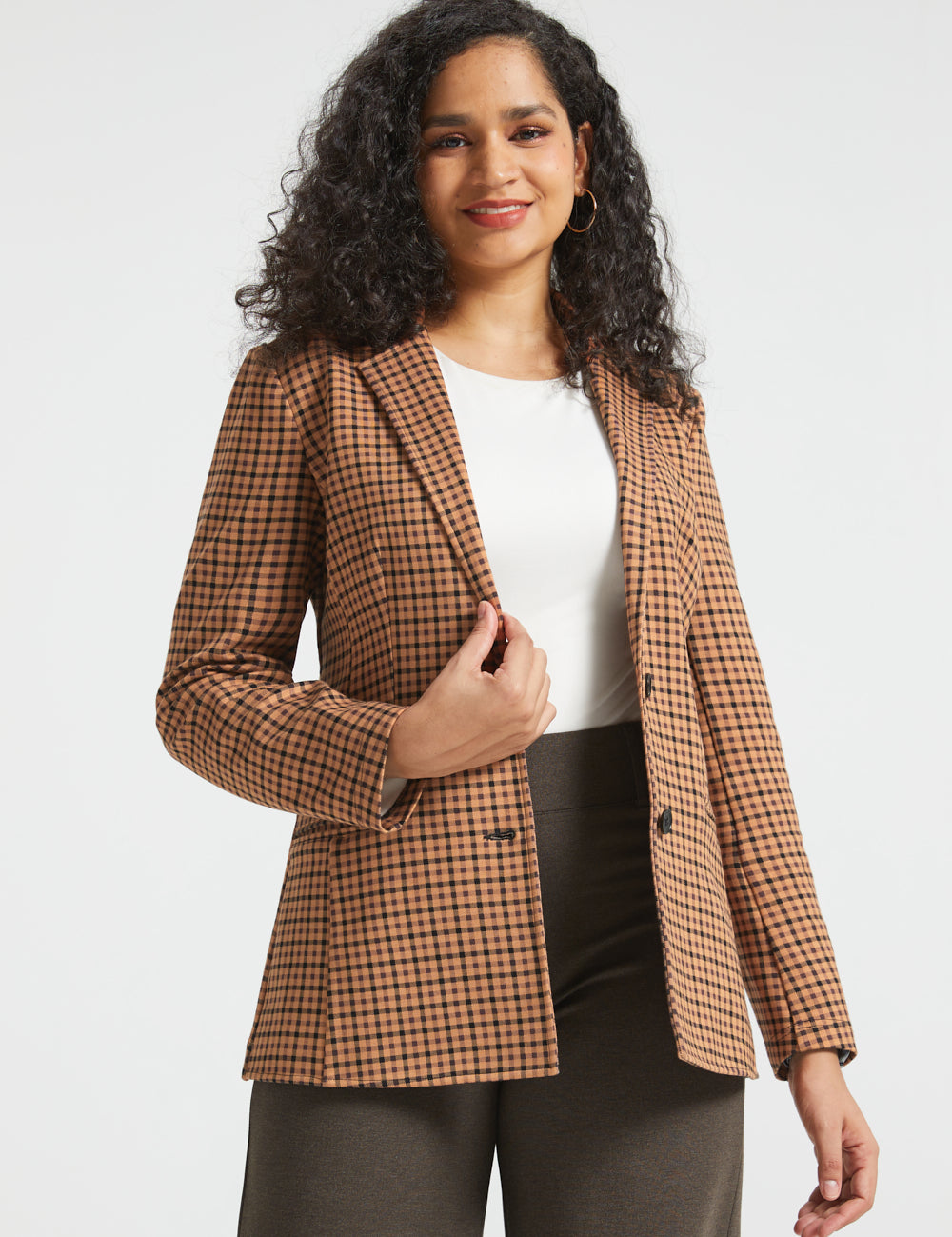 Woman wearing Camel Mini Houndstooth Classic Blazer open over a white top with brown wide-leg pants