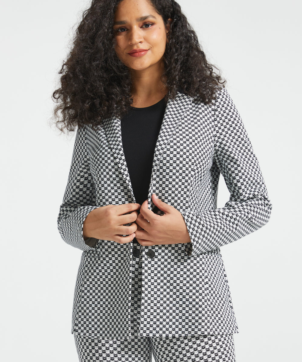 Woman wearing the Betabrand Black Ivory Catstooth Classic Blazer with matching cat print pants and a black top, front view