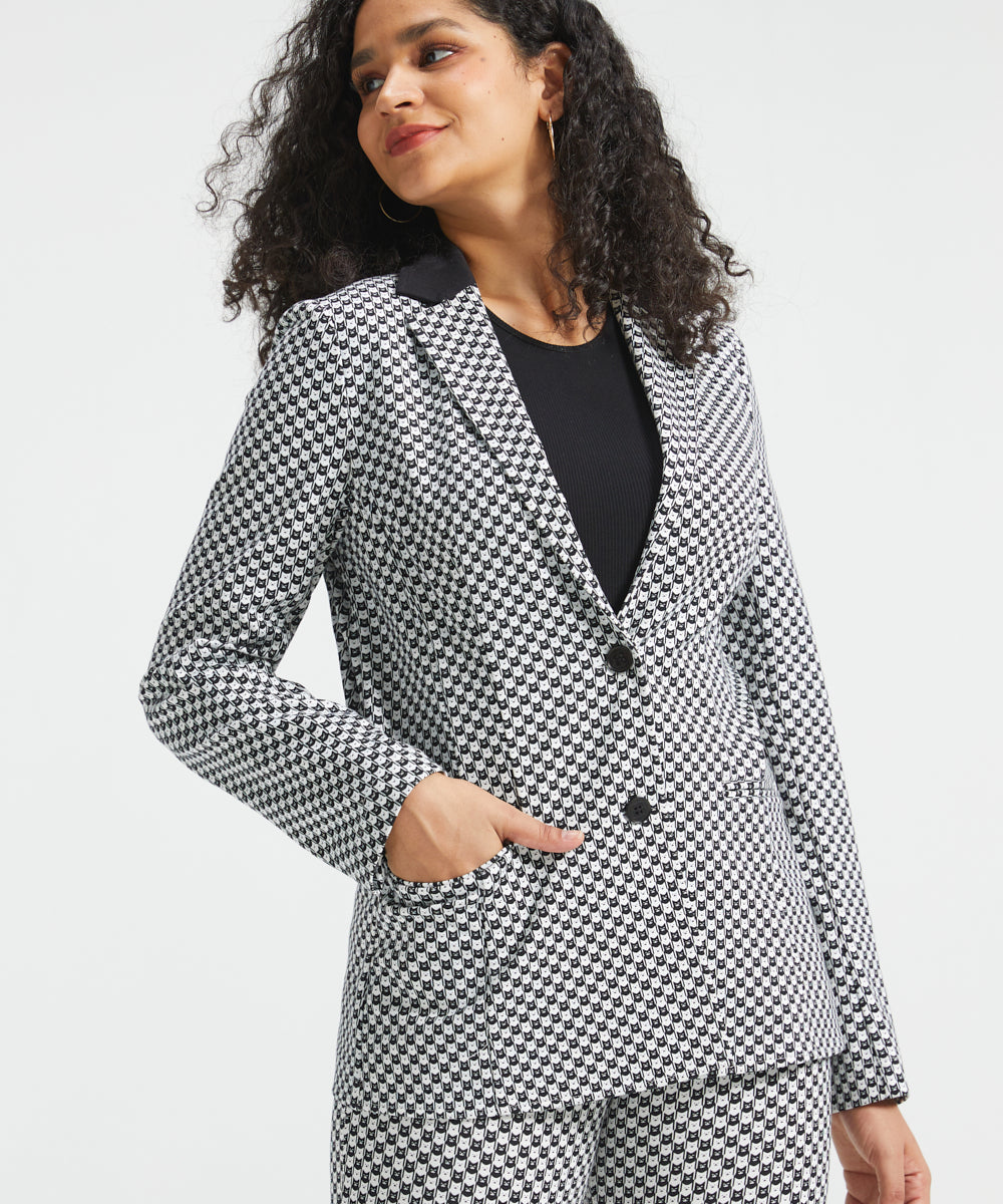 Woman wearing the black and ivory cat print Classic Blazer buttoned with one hand in the functional front pocket