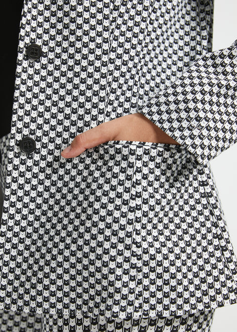 Close-up of the Betabrand cat print blazer showing the two-button front closure, functional welt pocket and sleeve cuff