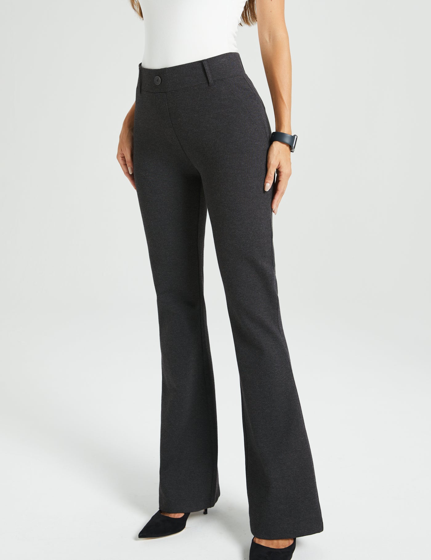 Dark gray flared dress pants worn by a woman on a white background